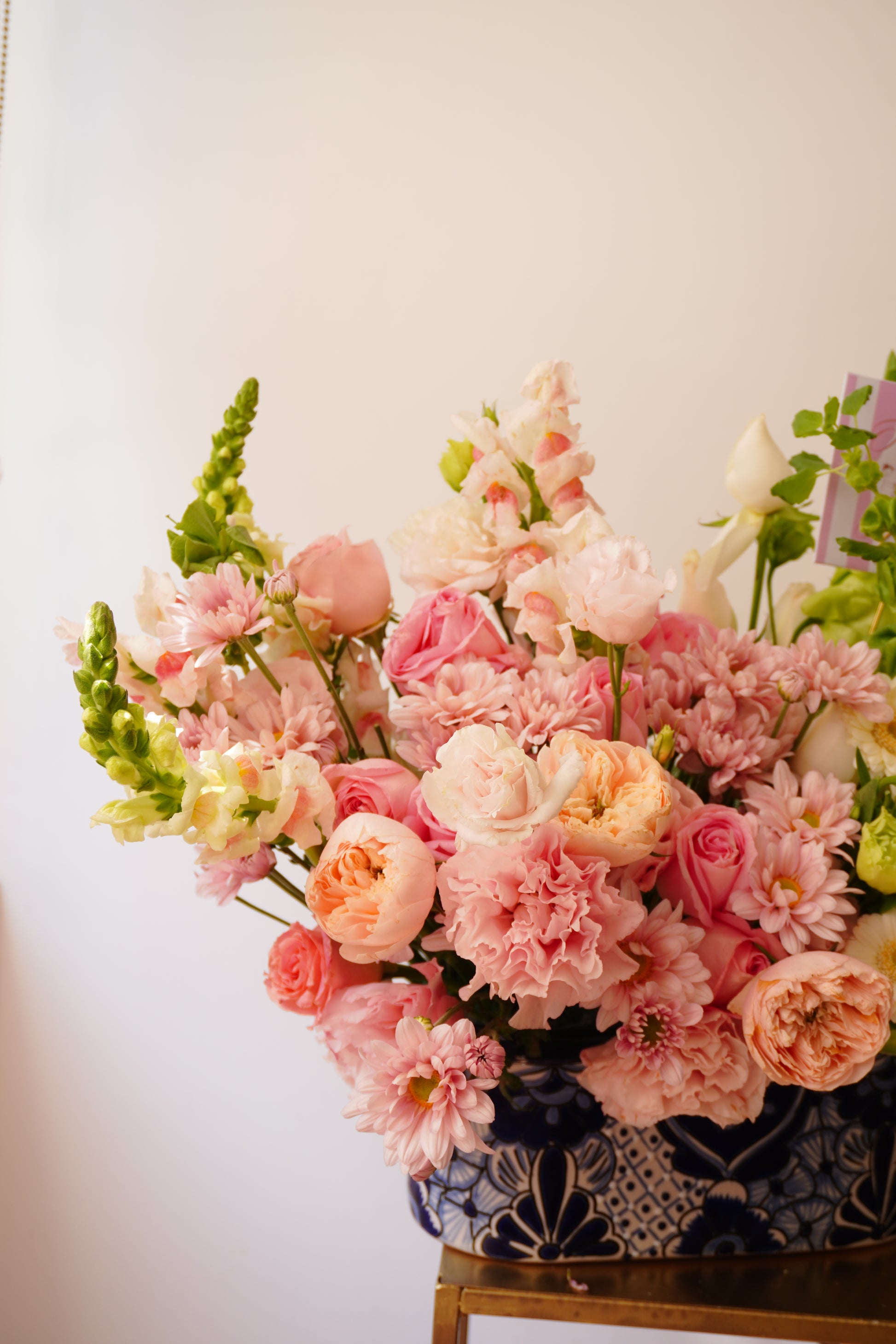 Arreglo floral con rosas rosas y verdes montado en base de Talavera
