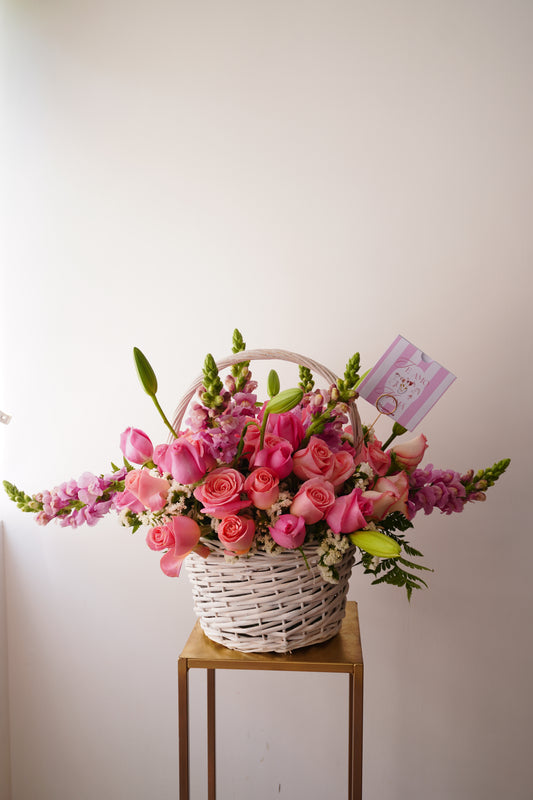 Canasta tipo picnic con rosas rosas y flores rosas